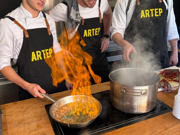 Chef-kok die gerechten bereidt met een spectaculaire vlam in de pan.