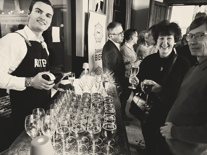 Sfeervolle zwart-wit foto van een feestelijke receptie met bediening bij een buffet.