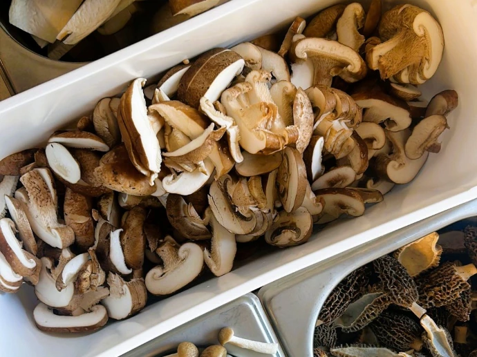 Close-up van verse gesneden champignons en ingrediënten voor bereiding.